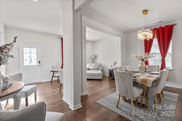 dining space with dark hardwood / wood-style flooring, plenty of natural light, and a chandelier