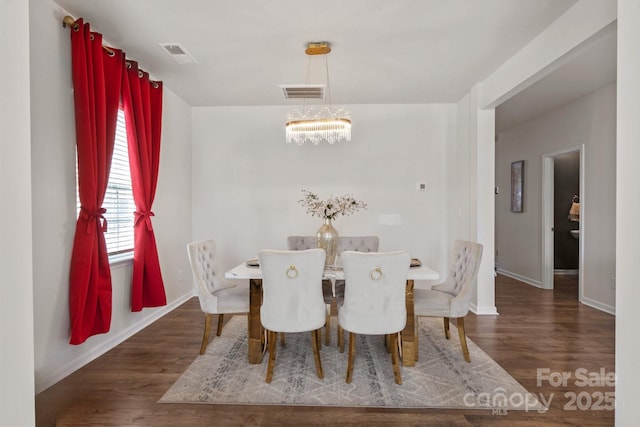 dining space featuring an inviting chandelier and dark wood-type flooring