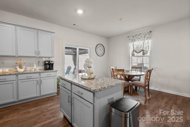 kitchen with dark hardwood / wood-style flooring, decorative backsplash, and gray cabinets