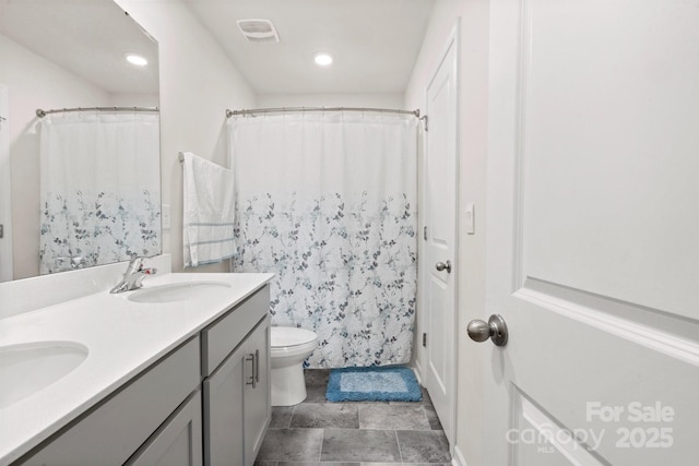 bathroom featuring vanity, toilet, and walk in shower