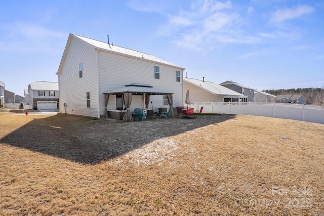 back of property featuring a garage and a gazebo