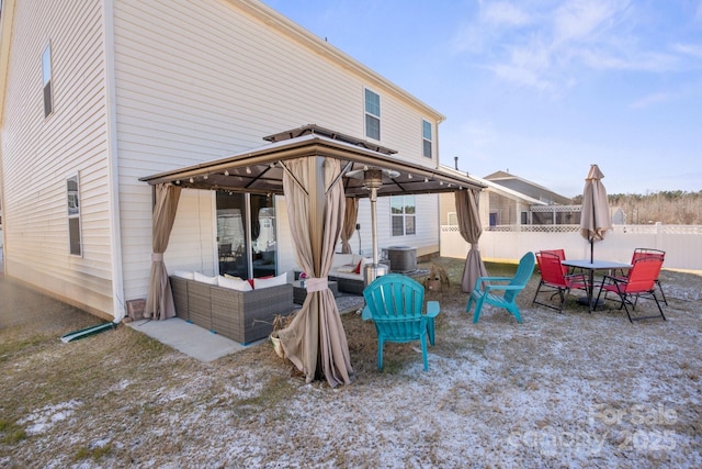 back of property featuring a gazebo and an outdoor hangout area