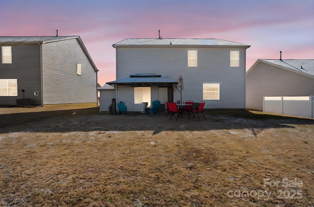 back house at dusk featuring a gazebo