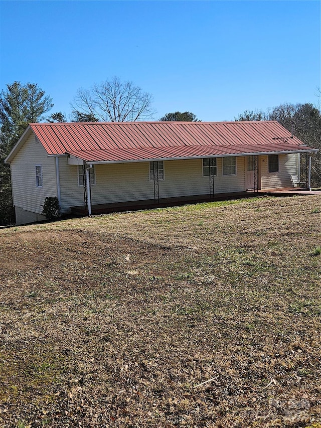 rear view of property featuring a lawn