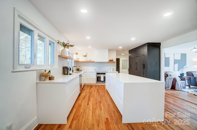 kitchen with white cabinetry, sink, light hardwood / wood-style floors, and appliances with stainless steel finishes