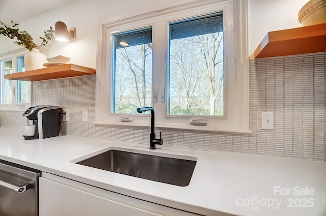 kitchen featuring sink, decorative backsplash, and stainless steel dishwasher