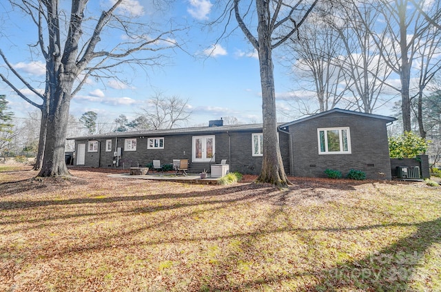 view of front of home featuring a patio, a front lawn, and central air condition unit