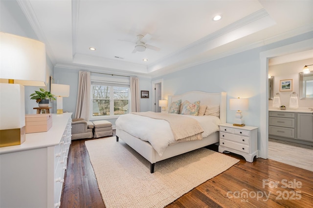 bedroom with a tray ceiling, dark wood-type flooring, and ornamental molding