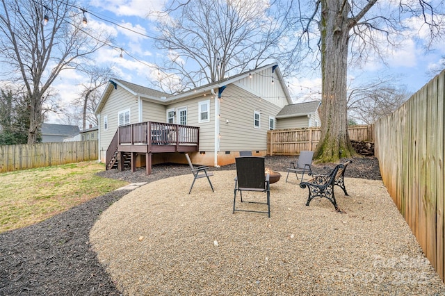 back of house with an outdoor fire pit and a deck