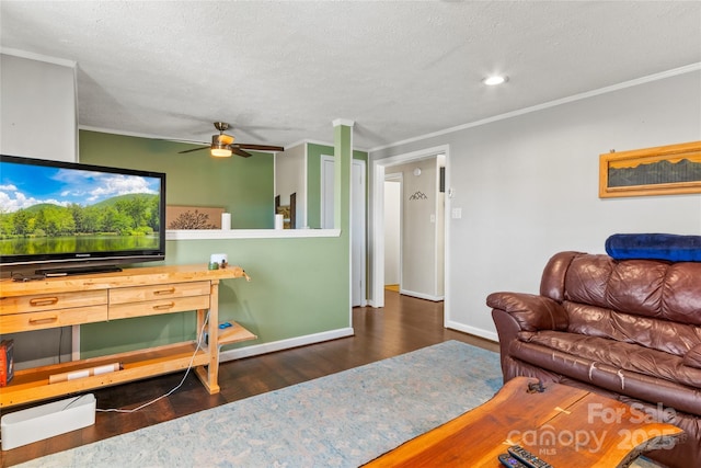 living room featuring dark hardwood / wood-style flooring, ceiling fan, crown molding, and a textured ceiling