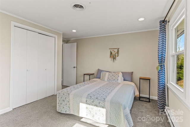 carpeted bedroom with baseboard heating, a closet, crown molding, and multiple windows