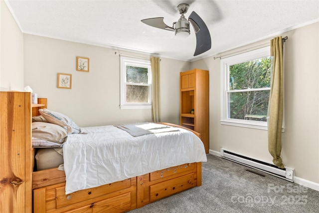 carpeted bedroom featuring baseboard heating, ceiling fan, and multiple windows