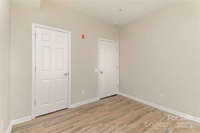 unfurnished bedroom featuring baseboards and light wood-style floors