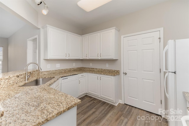 kitchen featuring a sink, white cabinetry, white appliances, and wood finished floors