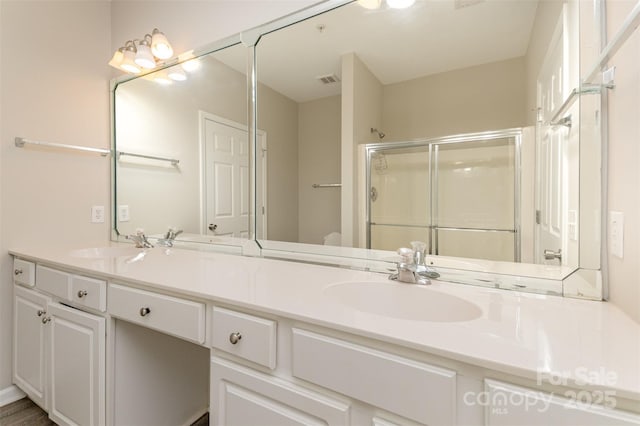 full bath with double vanity, visible vents, a sink, and a stall shower