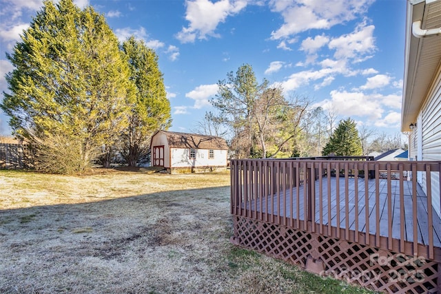 view of yard featuring a wooden deck and a storage shed