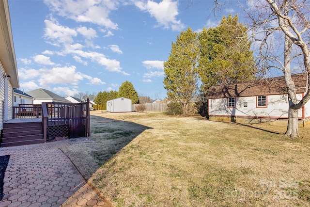 view of yard featuring a storage unit and a deck