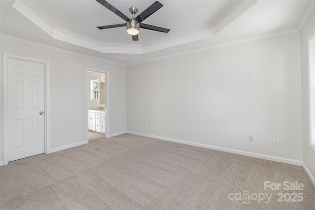 unfurnished bedroom featuring crown molding, light colored carpet, ceiling fan, and a tray ceiling