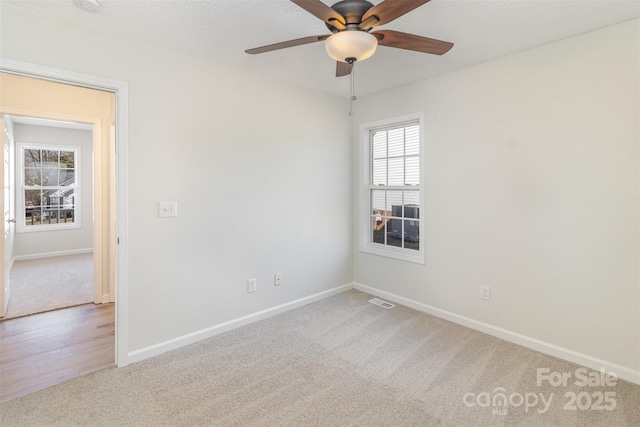 carpeted spare room featuring ceiling fan