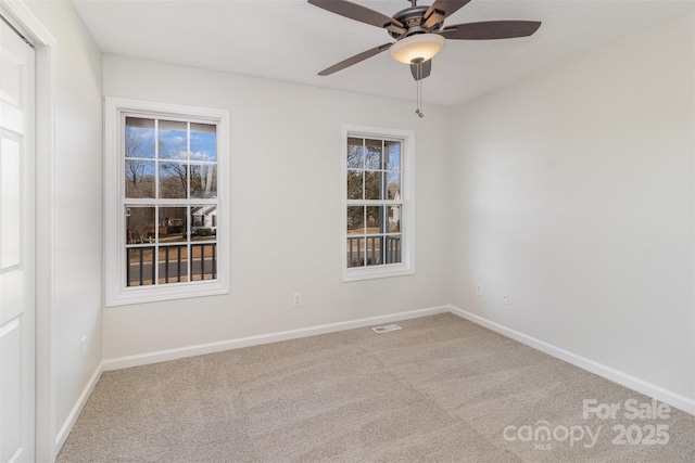 unfurnished room with light colored carpet and ceiling fan