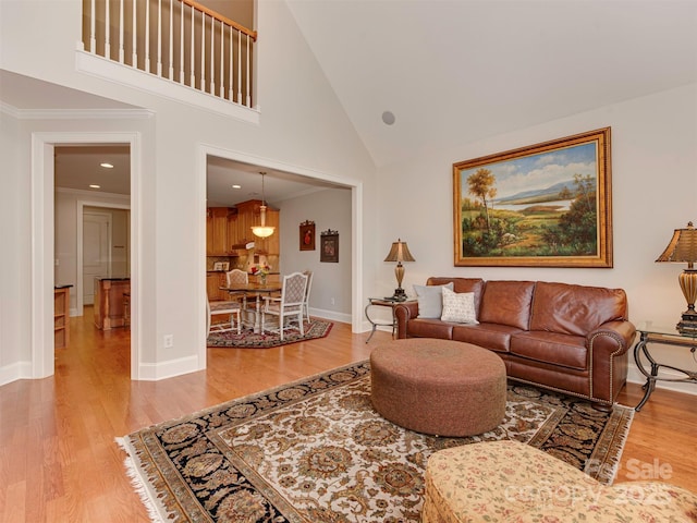 living room featuring hardwood / wood-style flooring, crown molding, and high vaulted ceiling