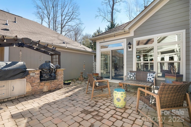 view of patio featuring an outdoor kitchen, a pergola, and area for grilling