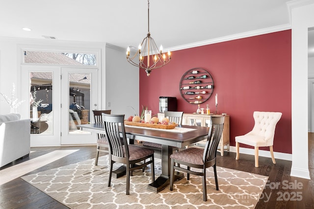 dining room featuring crown molding, wood-type flooring, and a chandelier