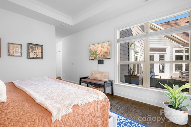 bedroom with a tray ceiling, ornamental molding, and dark hardwood / wood-style floors