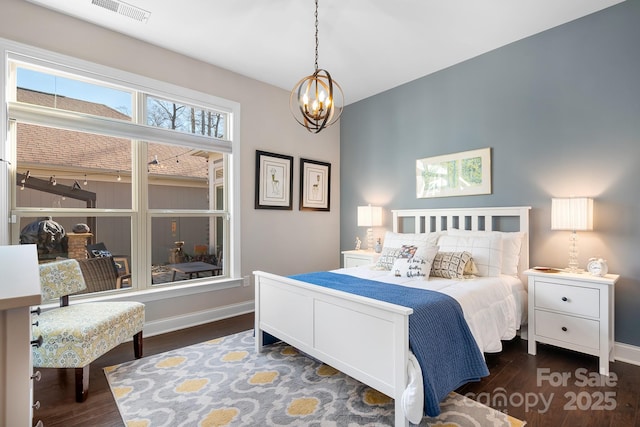 bedroom featuring dark hardwood / wood-style flooring and a notable chandelier