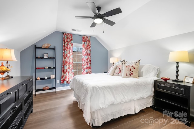 bedroom with dark wood-type flooring, ceiling fan, and vaulted ceiling