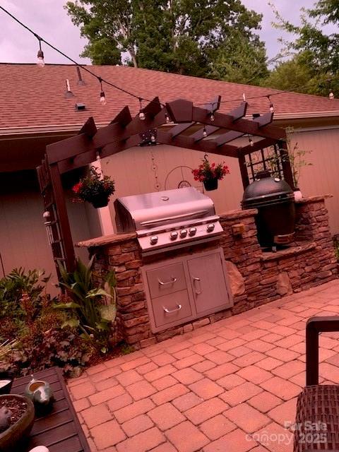 patio terrace at dusk featuring area for grilling and a pergola