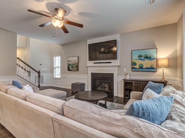 living room featuring ceiling fan, dark wood-type flooring, and a fireplace