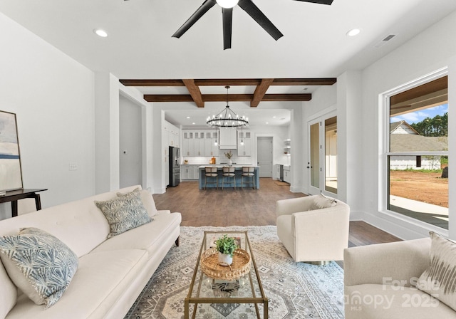 living room featuring beamed ceiling, ceiling fan with notable chandelier, and dark hardwood / wood-style flooring