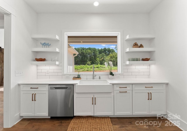 kitchen featuring tasteful backsplash, stainless steel dishwasher, white cabinetry, and sink