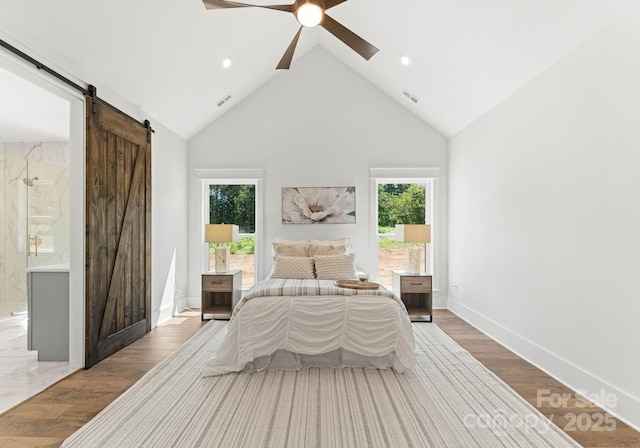 bedroom with hardwood / wood-style flooring, high vaulted ceiling, a barn door, and ceiling fan