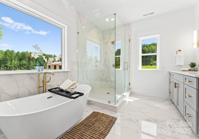 bathroom featuring vanity, plus walk in shower, and a wealth of natural light