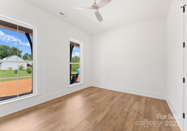 unfurnished room with ceiling fan and hardwood / wood-style floors