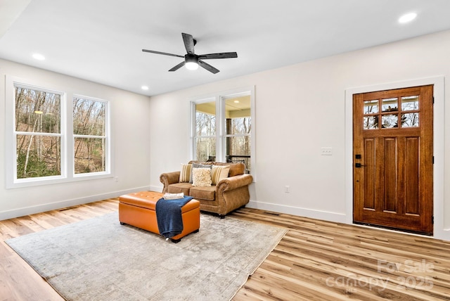 living room with ceiling fan and light hardwood / wood-style flooring