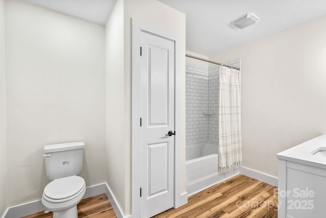 full bathroom featuring wood-type flooring, toilet, vanity, and shower / bath combo