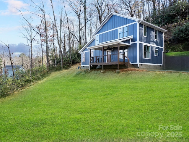 rear view of property featuring a lawn and covered porch