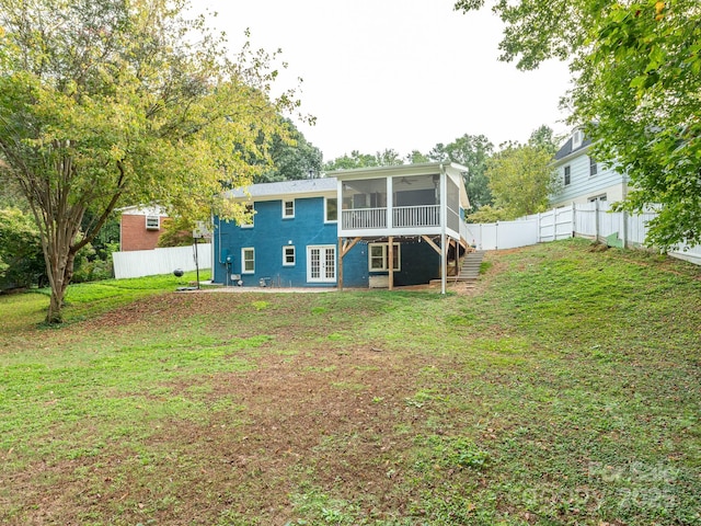 back of property with a yard and a sunroom