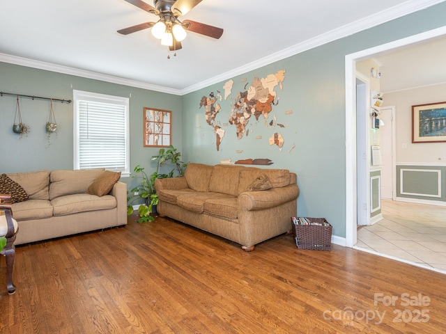 living room with ceiling fan, ornamental molding, and light hardwood / wood-style flooring