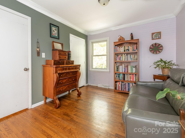 living area featuring ornamental molding and wood-type flooring