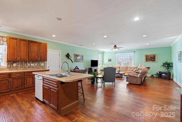 kitchen with sink, a breakfast bar area, dark wood-type flooring, a kitchen island with sink, and white dishwasher