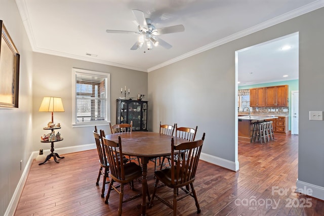 dining area with hardwood / wood-style floors, ornamental molding, and ceiling fan