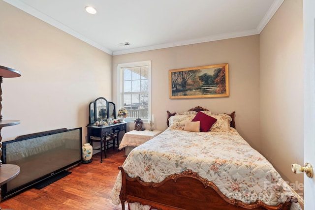 bedroom with wood-type flooring and ornamental molding