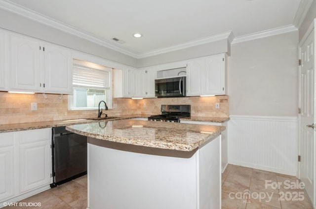 kitchen with light stone counters, a center island, stainless steel appliances, visible vents, and white cabinets