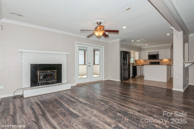 unfurnished living room with visible vents, baseboards, french doors, dark wood finished floors, and crown molding