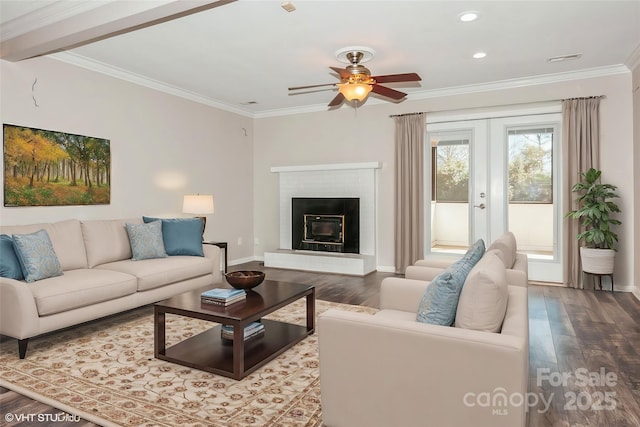 living room with ornamental molding, french doors, a fireplace, and wood finished floors