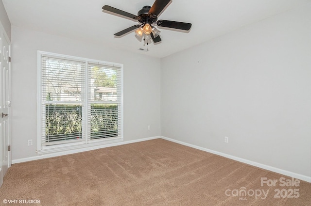 carpeted spare room featuring ceiling fan and baseboards